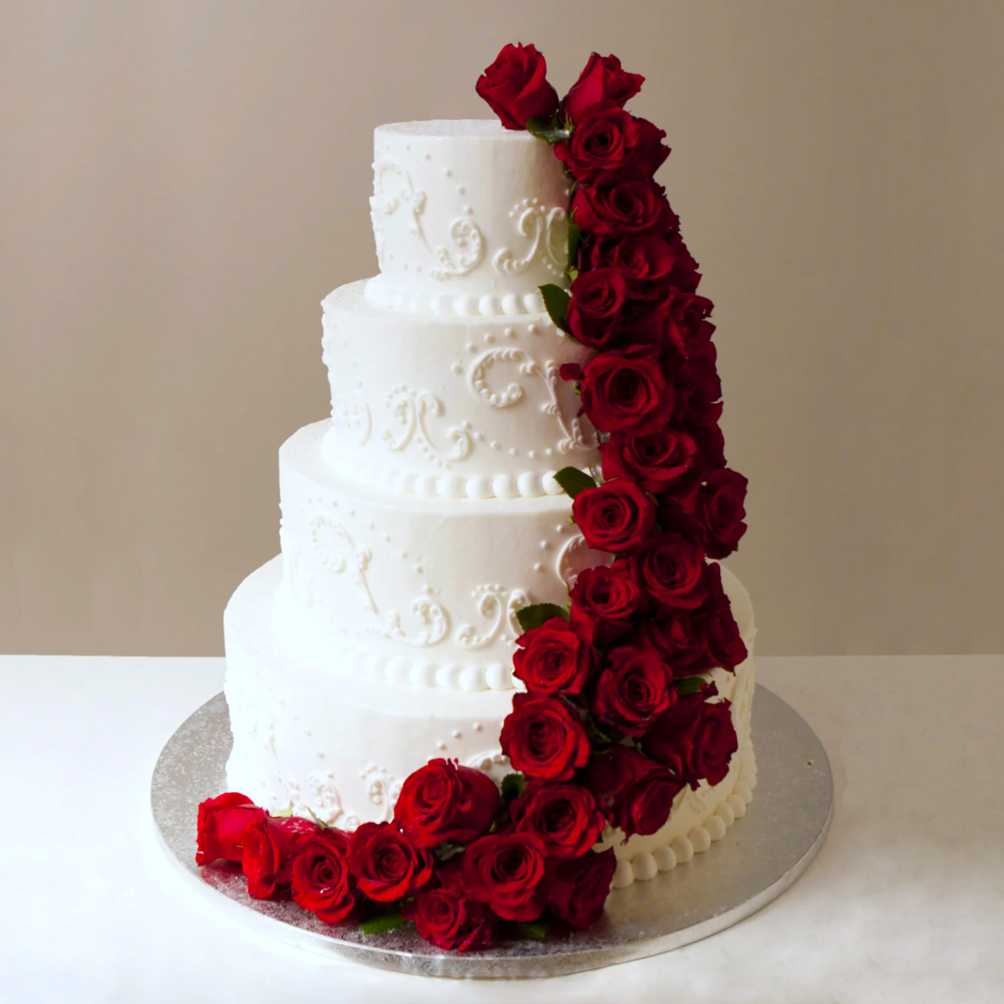 Photo of a four tier cake with red roses.